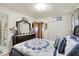 A well-lit main bedroom featuring a floral quilt, light walls and a dark wood dresser with decorative mirror at 2608 E 500 N, Whiteland, IN 46184