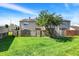 Backyard with a lush green lawn, wooden fence, mature tree, and exterior view of the home at 2642 Country Estates Dr, Indianapolis, IN 46227