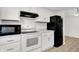 Bright kitchen features white cabinets, black appliances, and view of dining area at 2642 Country Estates Dr, Indianapolis, IN 46227