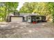 Back exterior view of home with attached garage, outdoor grill, and paved driveway at 3312 W 42Nd St, Indianapolis, IN 46228