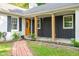 Inviting front porch with a brick pathway, beautiful landscaping, and a bright orange front door at 3312 W 42Nd St, Indianapolis, IN 46228