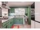 A kitchen featuring green cabinets, granite countertops, and stainless steel appliances for a sleek, modern look at 3312 W 42Nd St, Indianapolis, IN 46228