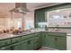 Kitchen featuring green cabinets, granite countertops, and stainless steel appliances for a modern and stylish appearance at 3312 W 42Nd St, Indianapolis, IN 46228