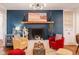 Stylish living room featuring a painted brick wall, fireplace, hardwood floors, and decorative lighting at 3312 W 42Nd St, Indianapolis, IN 46228