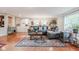 Spacious living room with hardwood floors, a large sectional sofa, and a decorative rug at 3312 W 42Nd St, Indianapolis, IN 46228