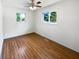 Bright bedroom featuring wood floors, a ceiling fan, and two windows with natural light at 3344 Southwest Dr, Indianapolis, IN 46241