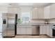 Modern kitchen features stainless steel appliances, gray cabinets, granite countertops, and a window over the sink at 3643 Thomas Jefferson St, Westfield, IN 46074
