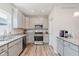 Well-lit kitchen with stainless steel appliances, gray cabinets, granite countertops, and a light-colored wooden floor at 3643 Thomas Jefferson St, Westfield, IN 46074