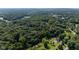Aerial view of a home with an in-ground pool surrounded by dense forest and a lake in the distance at 3715 Pitkin Rd, Martinsville, IN 46151