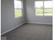 This is a carpeted bedroom with ample light from the large windows at 3824 Dutton Dr, Bargersville, IN 46106