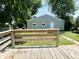 A backyard showcasing a green garage with a wooden deck in the foreground at 3835 N Kenwood Ave, Indianapolis, IN 46208