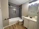 Cozy bathroom featuring a tub with tile surround, modern vanity, and neutral finishes at 3835 N Kenwood Ave, Indianapolis, IN 46208