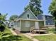 Charming exterior view of a home, showcasing its light green siding, small porch and well-manicured lawn at 3835 N Kenwood Ave, Indianapolis, IN 46208