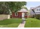 Quaint backyard with a well-maintained lawn, stone walkway, and charming red cottage-style home at 4226 Cornelius Ave, Indianapolis, IN 46208