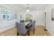 Well-lit dining room with hardwood floors, large window, and modern chandelier above the six-seat table at 4226 Cornelius Ave, Indianapolis, IN 46208