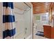 Bathroom featuring tiled floor, shower with striped curtain, toilet, vanity, sink, mirror, and wood paneling at 4418 North Dr, Quincy, IN 47456