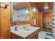 Bathroom with wood paneling, a mirror, and vanity with faux marble countertop and white sink at 4418 North Dr, Quincy, IN 47456