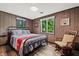 Cozy bedroom with rustic decor, wood-paneled walls, and natural light at 4418 North Dr, Quincy, IN 47456