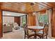 Charming dining area featuring wood walls, a round table, and seamless transition to the living room at 4418 North Dr, Quincy, IN 47456
