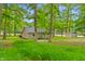 Stone home nestled among lush trees with vibrant green foliage and verdant grass at 4418 North Dr, Quincy, IN 47456
