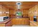 Compact kitchenette with wood cabinetry, a stainless steel sink, and natural lighting at 4418 North Dr, Quincy, IN 47456