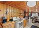Efficient kitchenette with wooden walls, appliances, and convenient access to the dining area at 4418 North Dr, Quincy, IN 47456