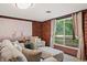 Bright living room with brick walls, stylish seating, and natural light through a window at 4418 North Dr, Quincy, IN 47456