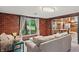 Bright living room with brick walls, comfortable seating, and natural light through a window at 4418 North Dr, Quincy, IN 47456