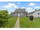 Spacious backyard with a lush lawn, mature trees, and a convenient pathway to the home at 4813 E 11Th St, Indianapolis, IN 46201