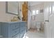 Charming bathroom with a blue vanity, exposed brick, and white tiled shower at 4813 E 11Th St, Indianapolis, IN 46201