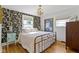 Cozy bedroom featuring a metal bed frame, floral wallpaper, and hardwood floors at 4813 E 11Th St, Indianapolis, IN 46201