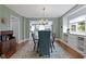 Dining area with an elegant light fixture with views into the modern kitchen at 4813 E 11Th St, Indianapolis, IN 46201