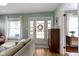 Bright living room featuring hardwood floors, large windows, and an inviting front door at 4813 E 11Th St, Indianapolis, IN 46201