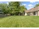 Large private backyard featuring a lush lawn, mature trees, a screened porch, and a hot tub at 5037 Surrey Ln, Carmel, IN 46033