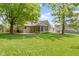Beautiful backyard with lush green lawn, mature trees, patio, screened porch, and well-maintained landscaping at 5037 Surrey Ln, Carmel, IN 46033
