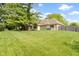 A large, well-manicured backyard with mature trees, green lawn, hot tub, and screened-in porch at 5037 Surrey Ln, Carmel, IN 46033