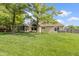 Expansive backyard with a screened porch, hot tub, mature trees, and a sprawling green lawn at 5037 Surrey Ln, Carmel, IN 46033