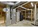 Unfinished basement area containing mechanicals like a furnace, water heater, and shelving at 5037 Surrey Ln, Carmel, IN 46033