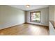 This bedroom offers hardwood floors and natural light from the window with neighborhood views at 5037 Surrey Ln, Carmel, IN 46033