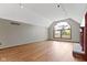 Spacious living room with hardwood floors, fireplace, and large arched window at 5037 Surrey Ln, Carmel, IN 46033