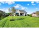 Spacious backyard with well-maintained lawn, shade tree and a glimpse of the back patio at 5668 Champion Way, Greenwood, IN 46143