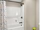 Clean bathroom with a white shower and black hardware and a colorful shower curtain at 5668 Champion Way, Greenwood, IN 46143