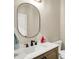 A half-bath features a modern sink and faucet, with a decorative oval mirror above at 5668 Champion Way, Greenwood, IN 46143