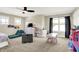 Well-lit bedroom with two large windows, carpet, ceiling fan, and a area with toys and table at 5668 Champion Way, Greenwood, IN 46143