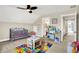 Cozy bedroom with a crib, a play kitchen, a small table with chairs and a fun alphabet rug at 5668 Champion Way, Greenwood, IN 46143