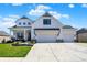 Charming two-story home boasting a welcoming front porch, white exterior, and an expansive three-car driveway at 5668 Champion Way, Greenwood, IN 46143