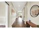Long hallway with hardwood floors, neutral walls, decorative art, and access to various rooms in the home at 5668 Champion Way, Greenwood, IN 46143