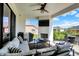 Relaxing covered patio featuring comfortable seating, an outdoor television and a fireplace at 5668 Champion Way, Greenwood, IN 46143