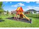Colorful backyard playset with slide and swings offers a great space for outdoor playtime and recreation at 5668 Champion Way, Greenwood, IN 46143