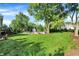Spacious backyard with lush green lawn, mature trees, firepit, and deck at 586 Shady Creek Dr, Greenwood, IN 46142